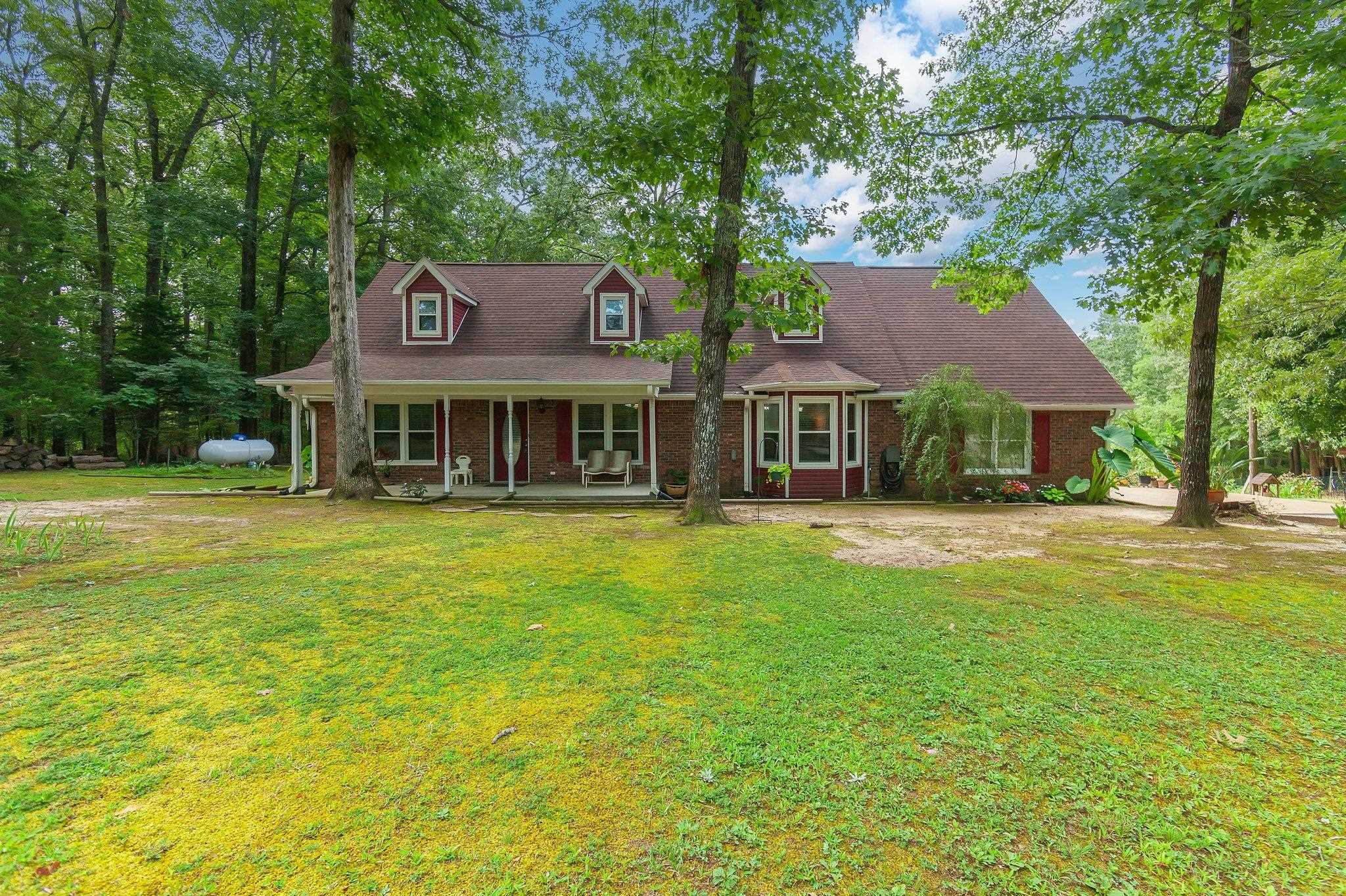 New england style home featuring covered porch and a front yard