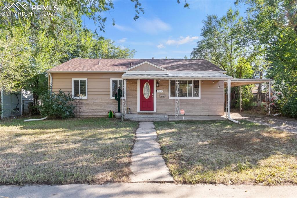 Ranch-style home with a front lawn and a carport