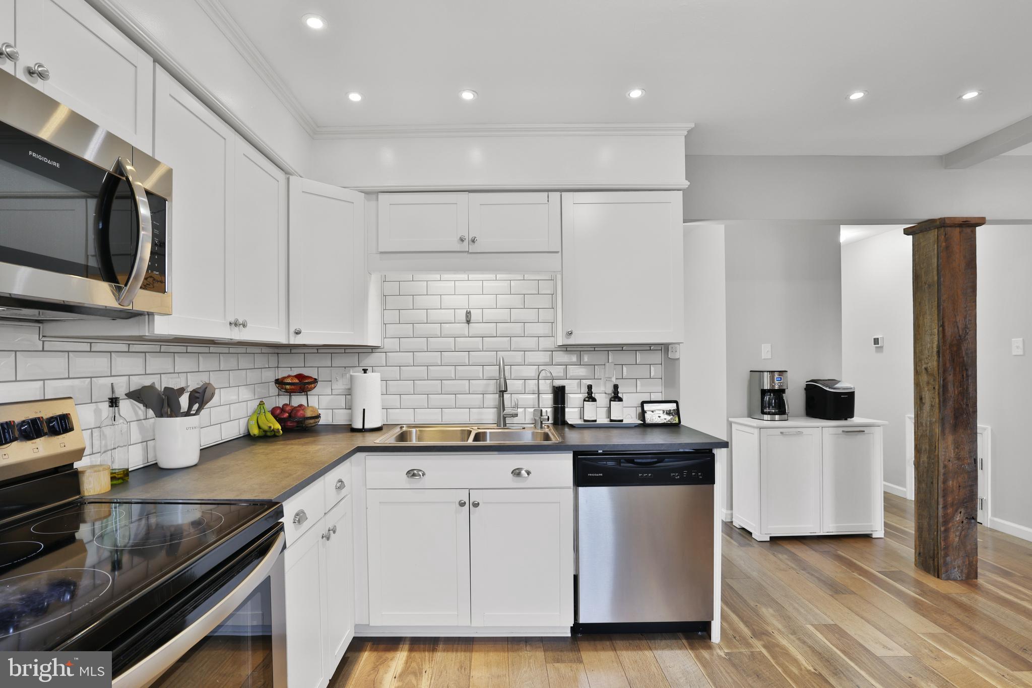 a kitchen with stainless steel appliances a stove sink microwave and cabinets