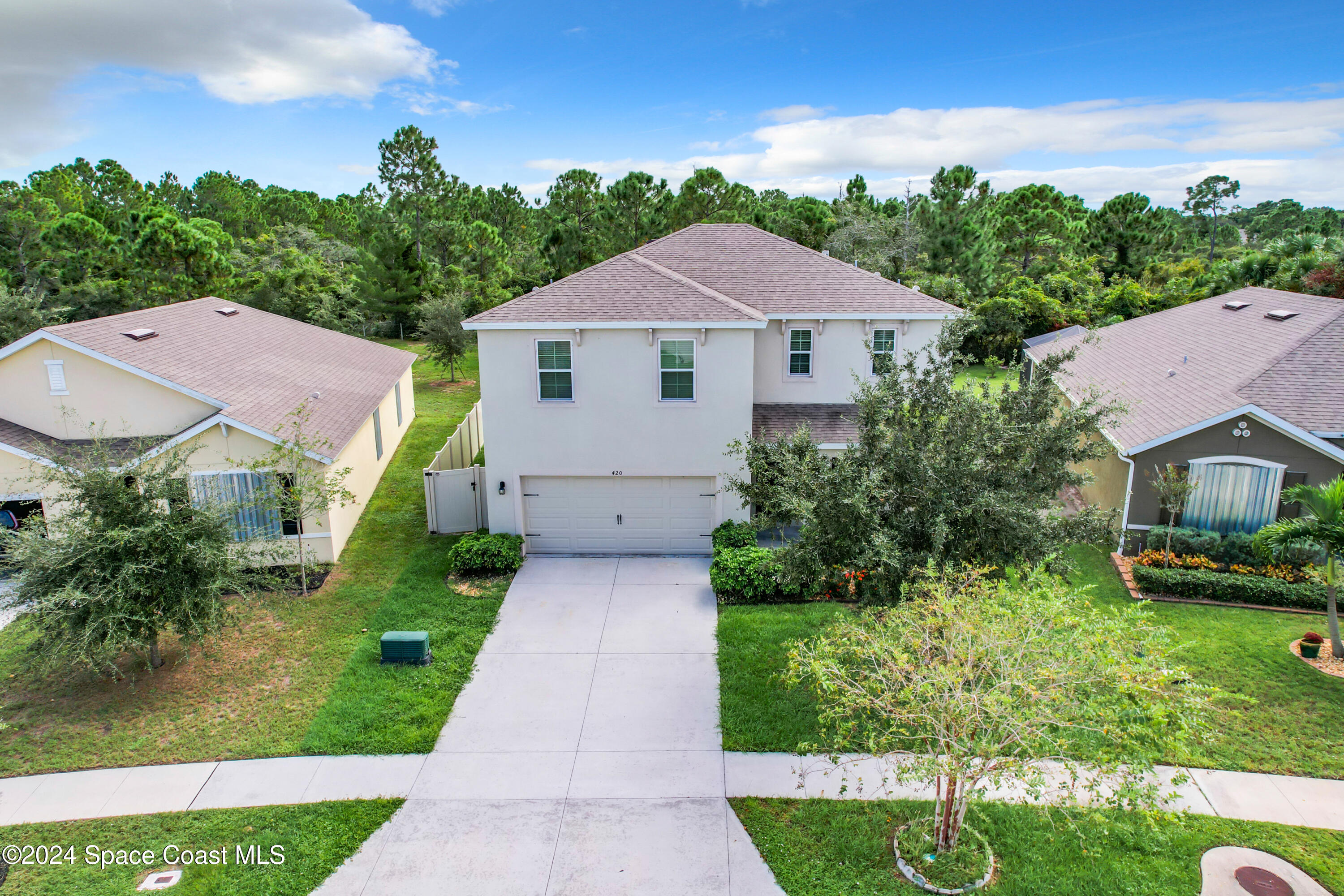 a aerial view of a house with yard and green space