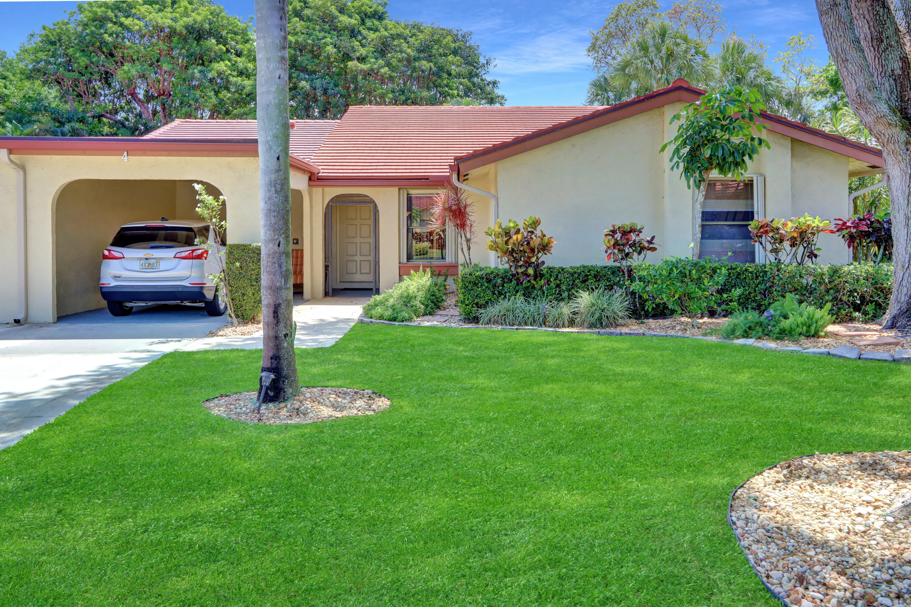 a front view of a house with a garden and plants