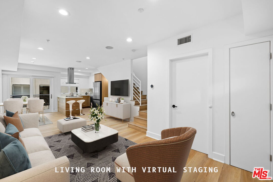 a living room with furniture and a view of kitchen