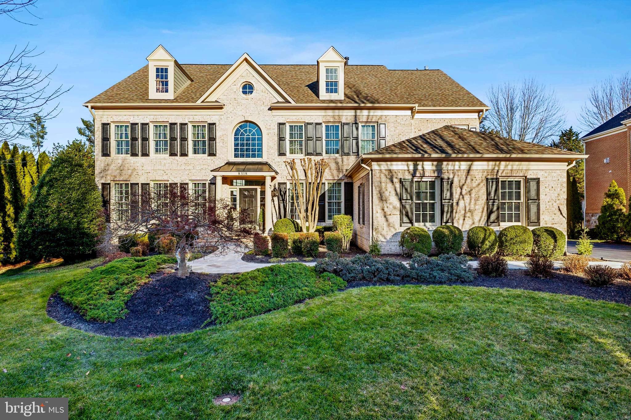 a front view of a house with a yard and potted plants