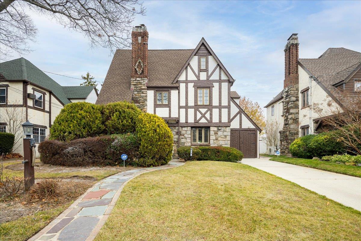 Tudor-style house featuring a front lawn