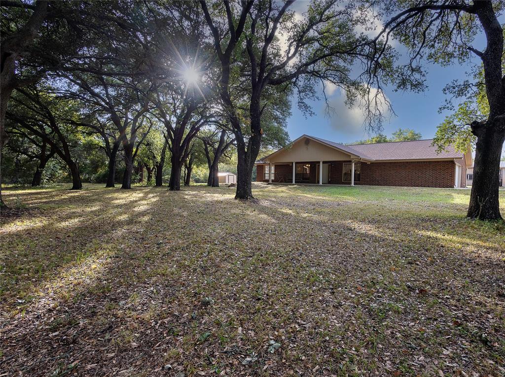 a front view of a house with a yard and trees