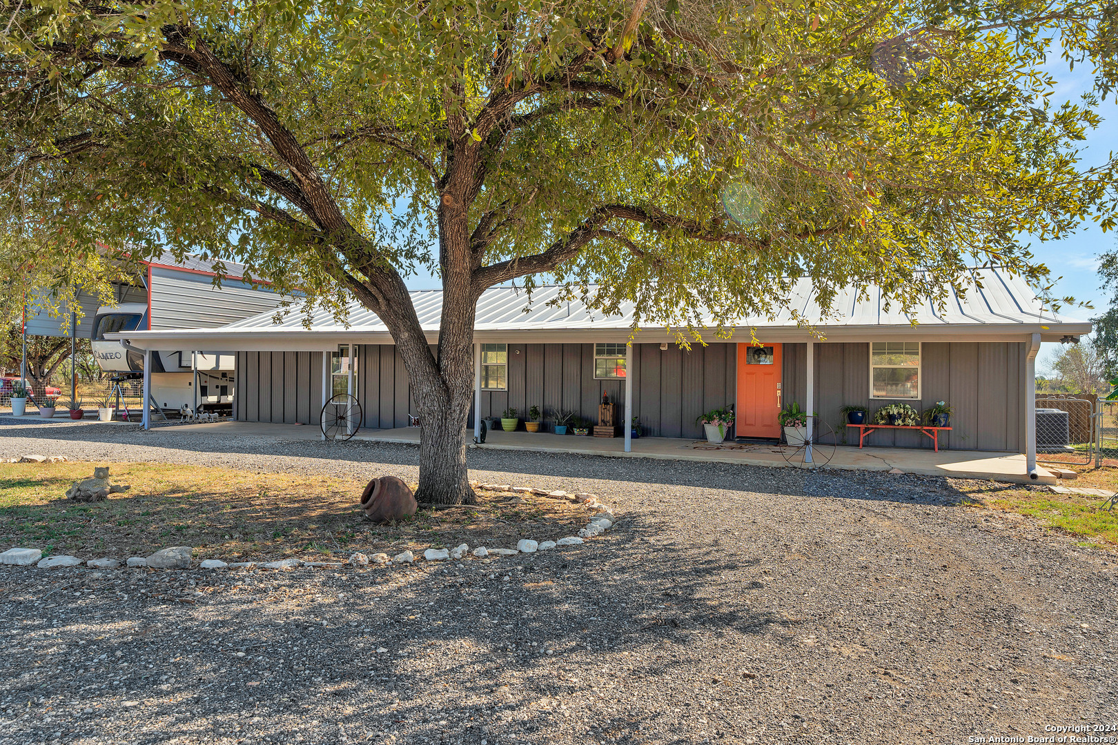 a front view of a house with a tree