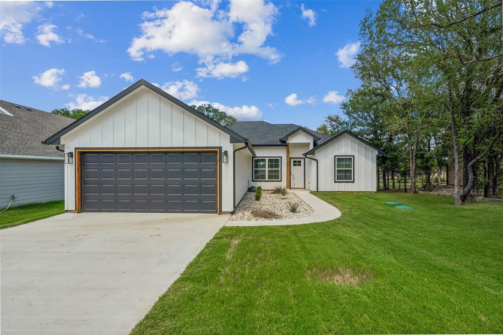 a front view of house with yard and garage