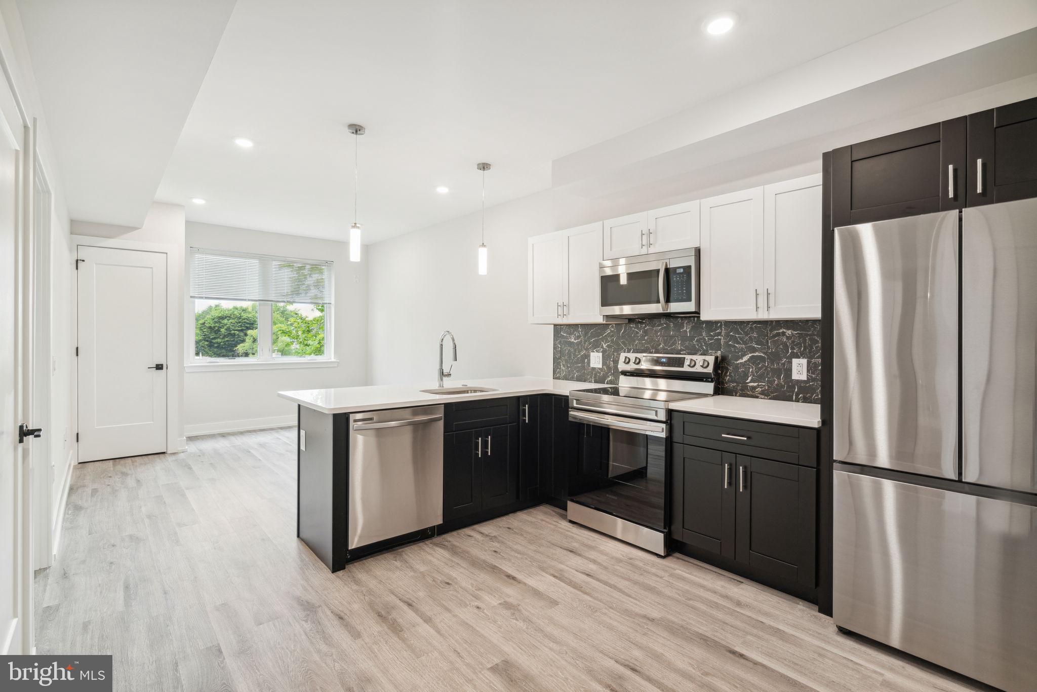 a kitchen with a refrigerator and a stove top oven