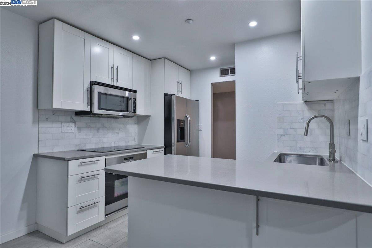 a kitchen with appliances a sink cabinets and a counter top space