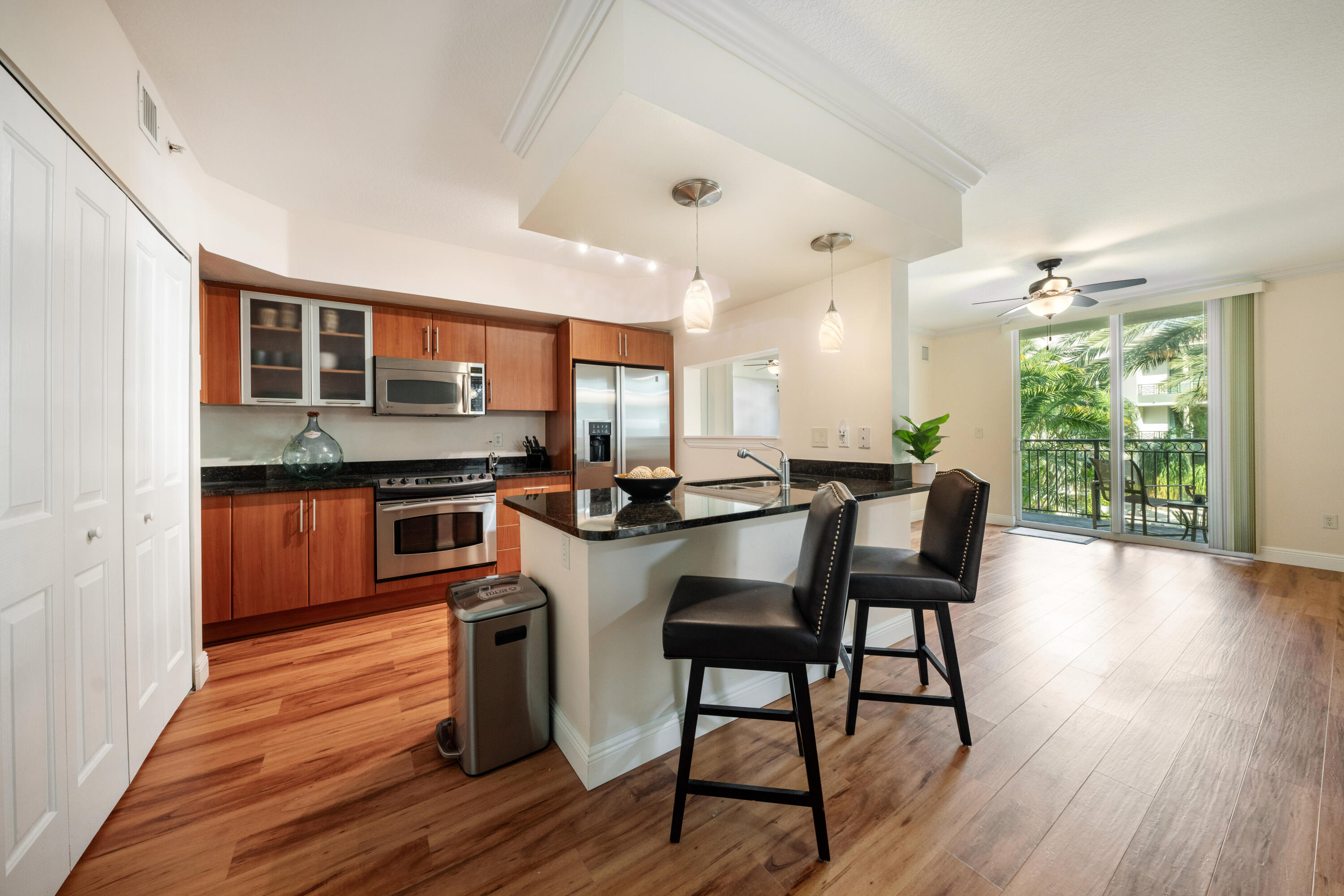 a kitchen with stainless steel appliances a dining table chairs stove and refrigerator