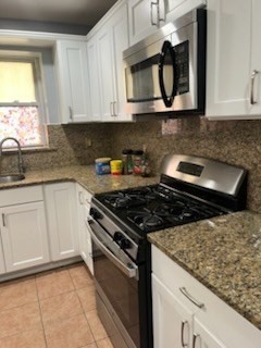 a kitchen with stainless steel appliances granite countertop white cabinets and stove