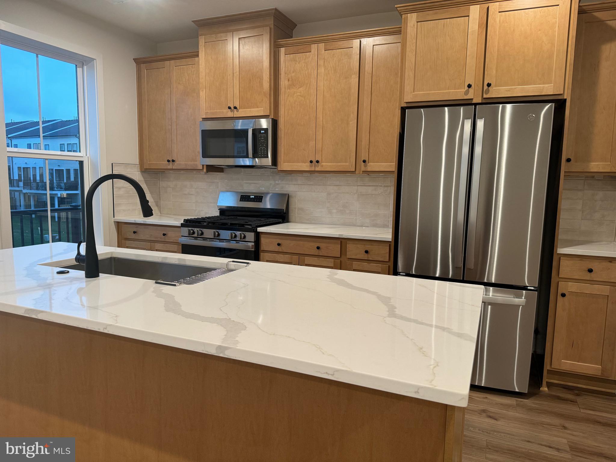 a kitchen with stainless steel appliances a refrigerator microwave and sink