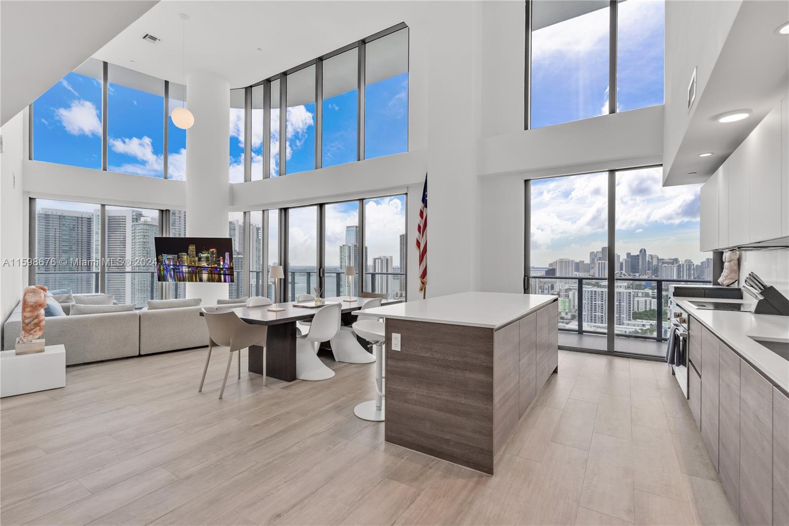 a living room with furniture a fireplace and large windows