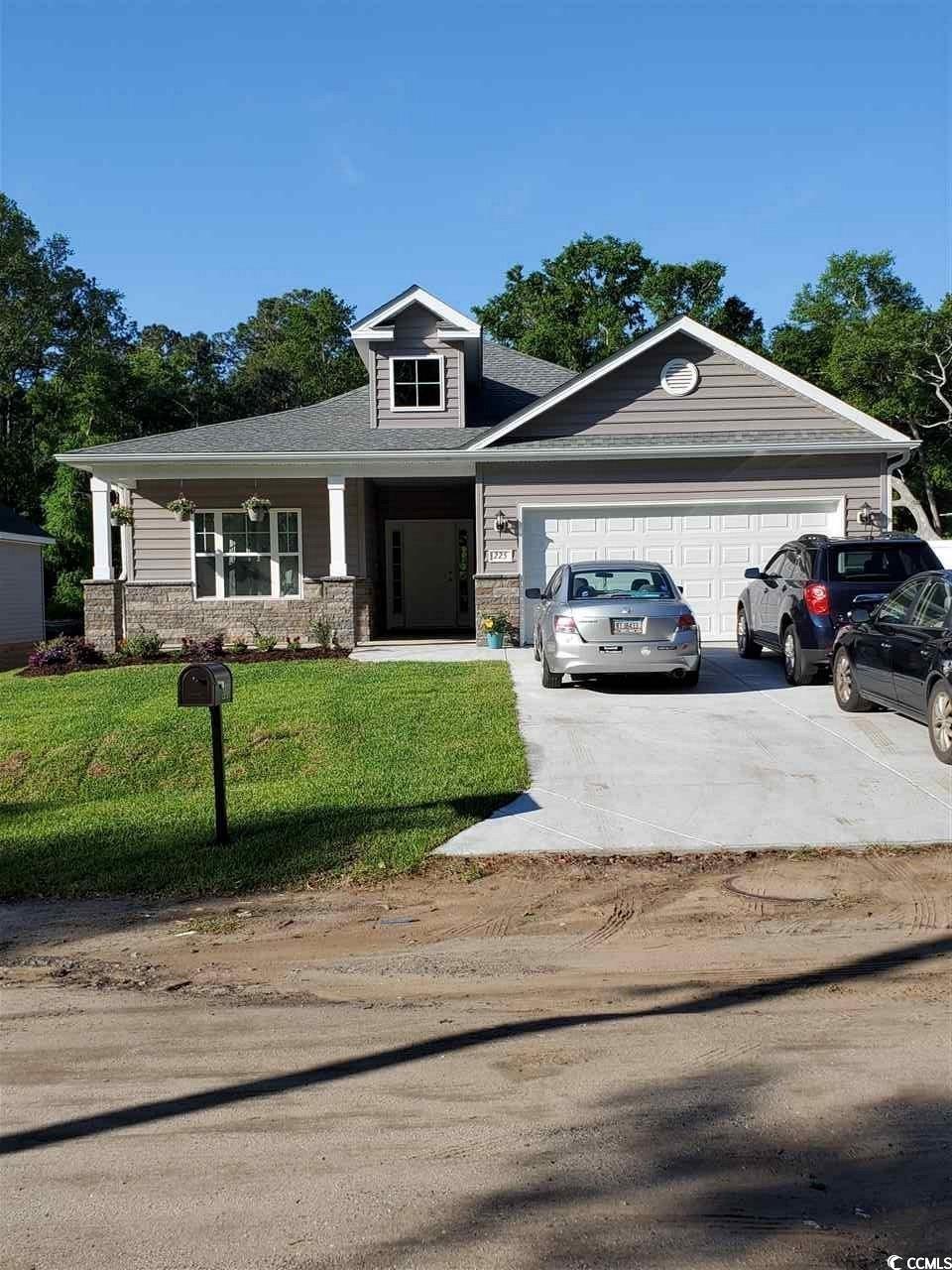 View of front facade with a front lawn, a porch, a