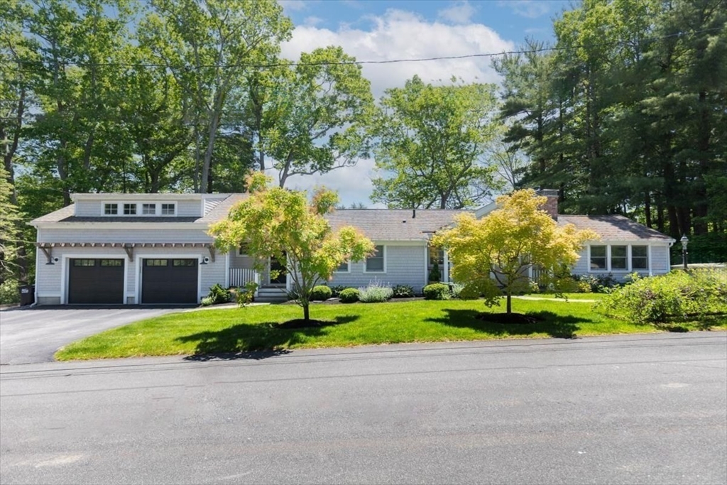 a view of a house with a yard and large trees