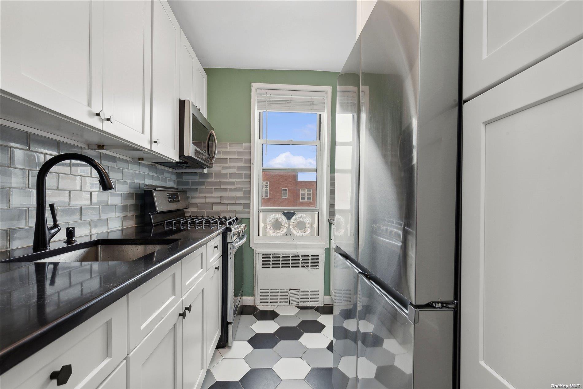 a kitchen with stainless steel appliances granite countertop a refrigerator and a sink