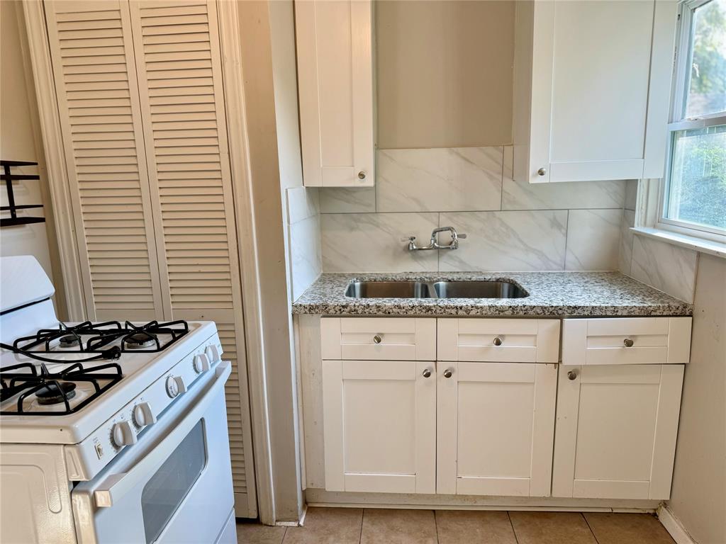 a kitchen with granite countertop white cabinets and white appliances