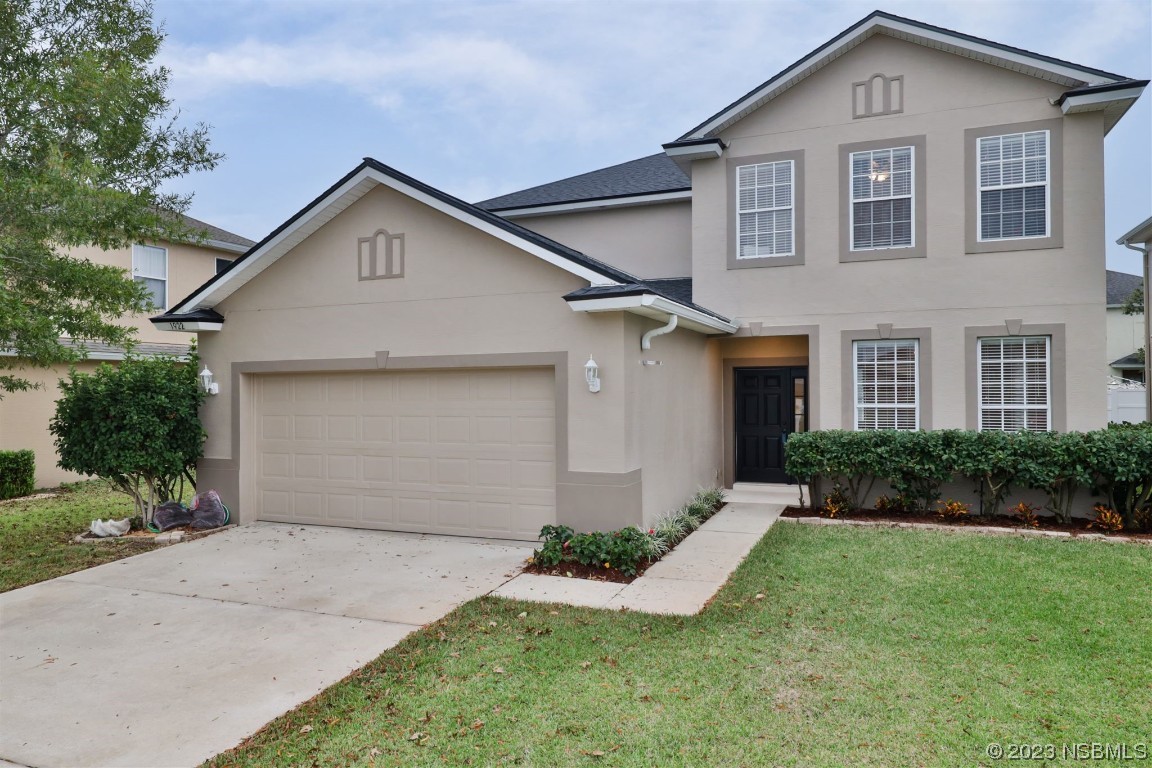 a front view of a house with a yard and garage