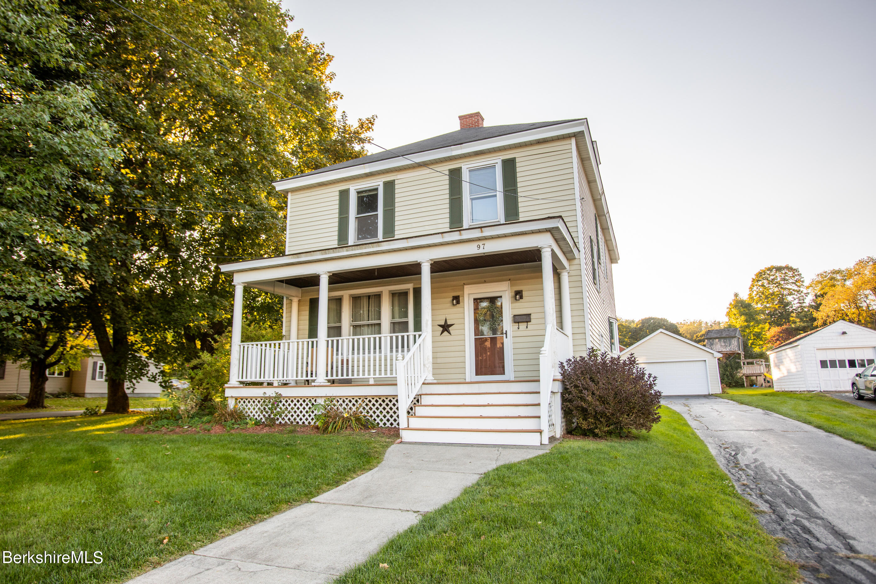 a front view of a house with a yard and trees