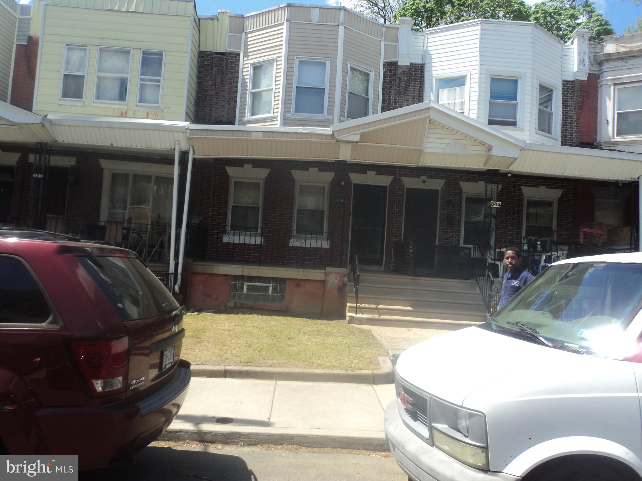 a view of a house with a floor to ceiling windows and a yard