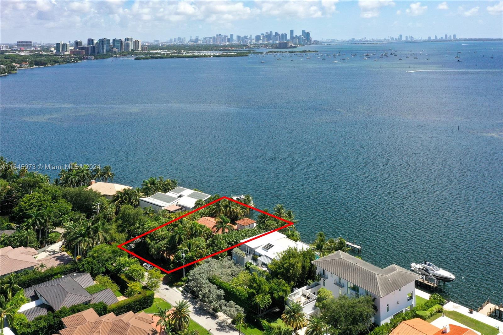 an aerial view of a house with a yard and lake view