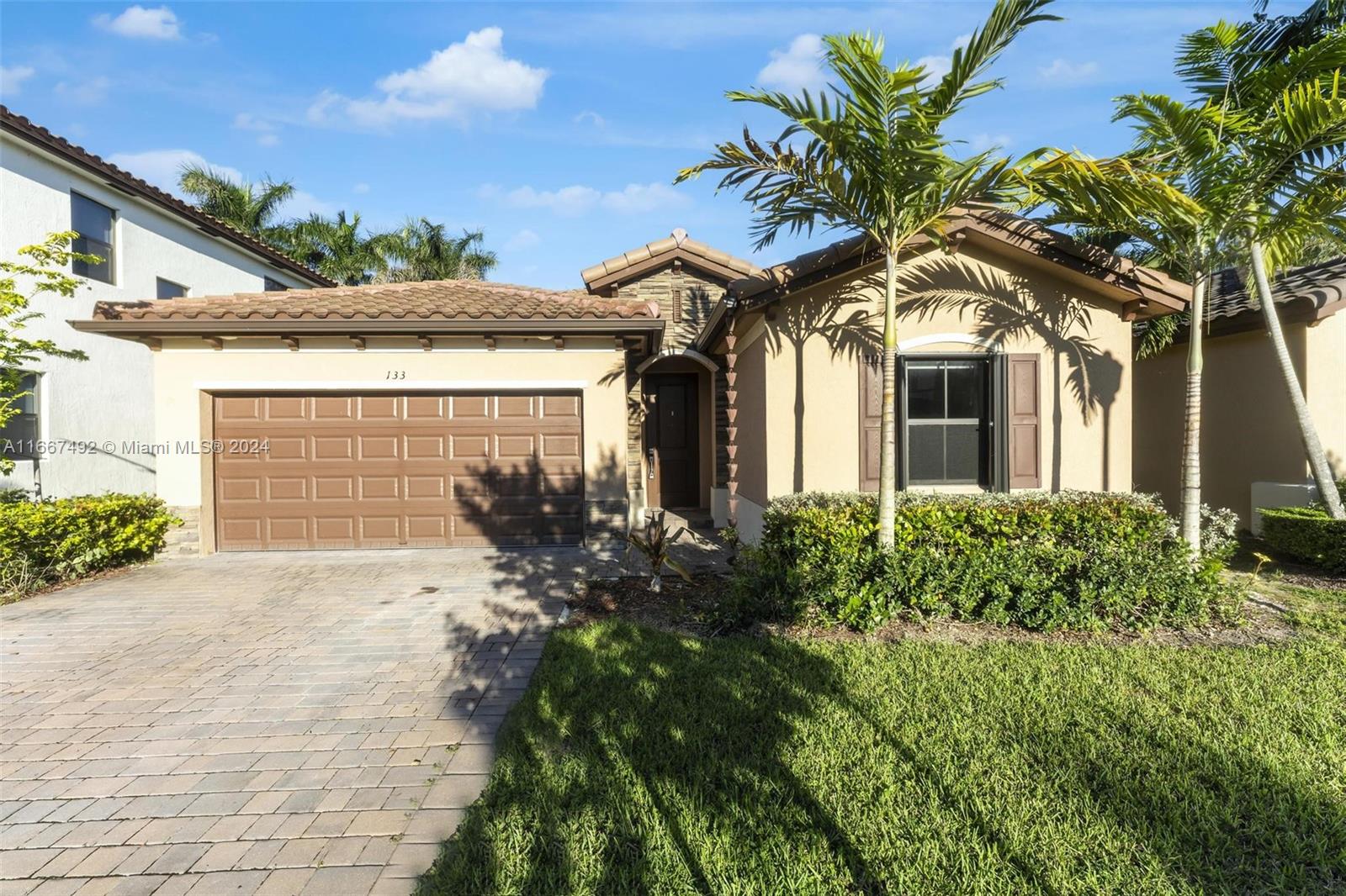 a front view of a house with a yard and garage