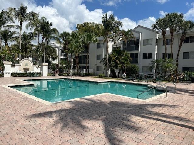 a view of backyard with swimming pool and outdoor seating