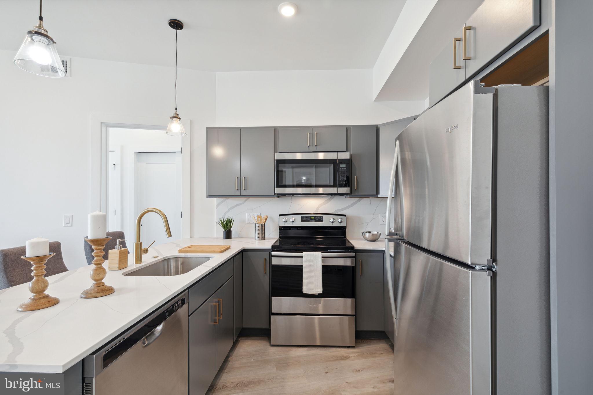 a kitchen with stainless steel appliances a refrigerator sink and microwave