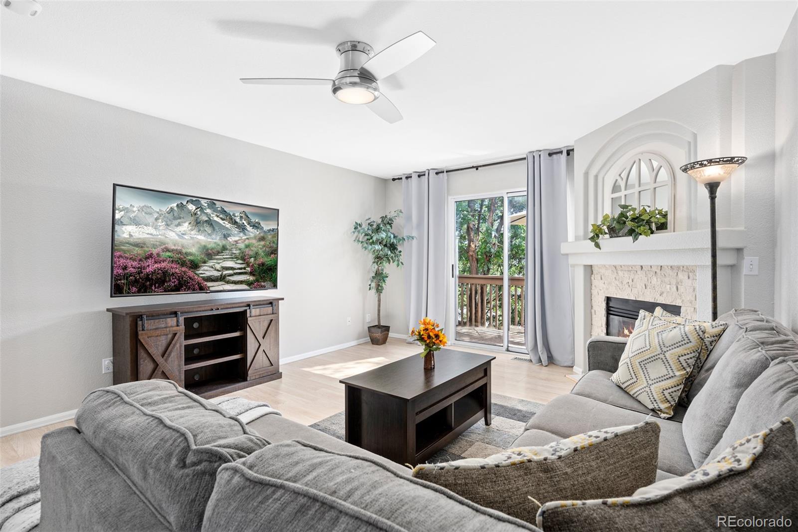 a living room with furniture a fireplace and a flat screen tv