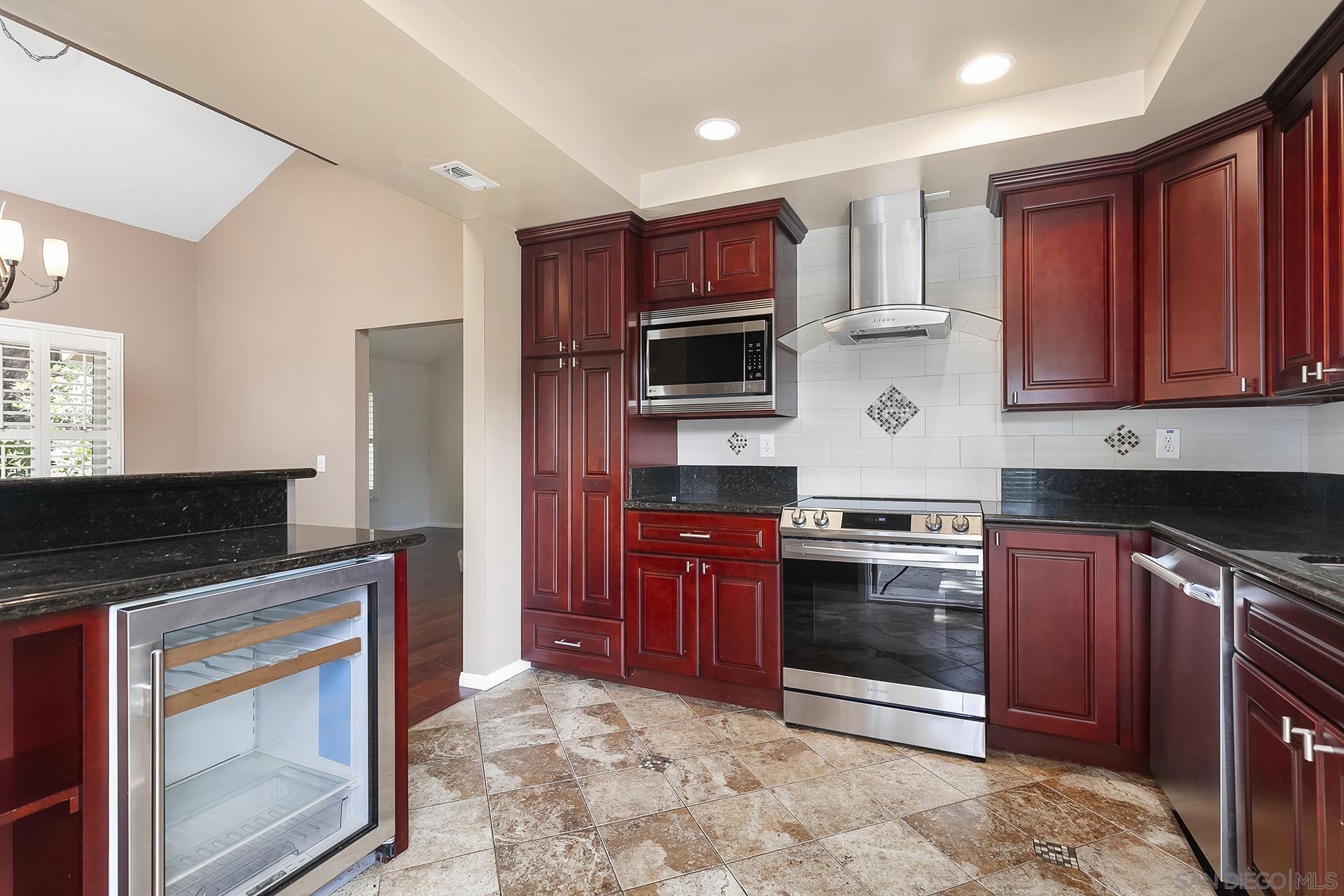 a kitchen with stainless steel appliances granite countertop a stove top oven microwave and cabinets