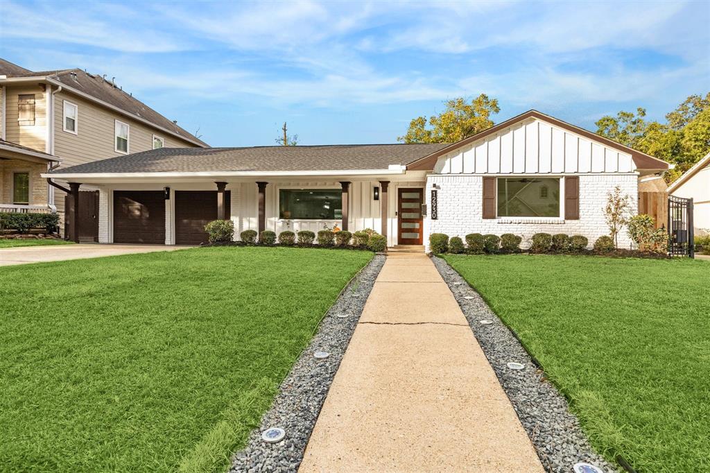 Modern single-story home in highly sought after subdivision of Memorial Bend.  It features a neatly landscaped front yard, a two-car garage, and a welcoming pathway leading to the front door.