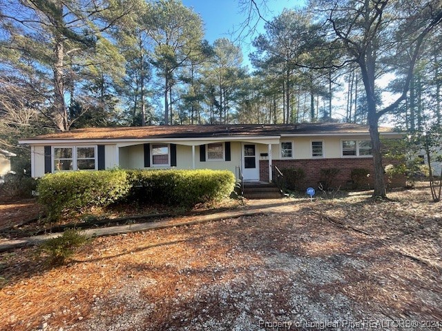 a front view of house with yard and trees around