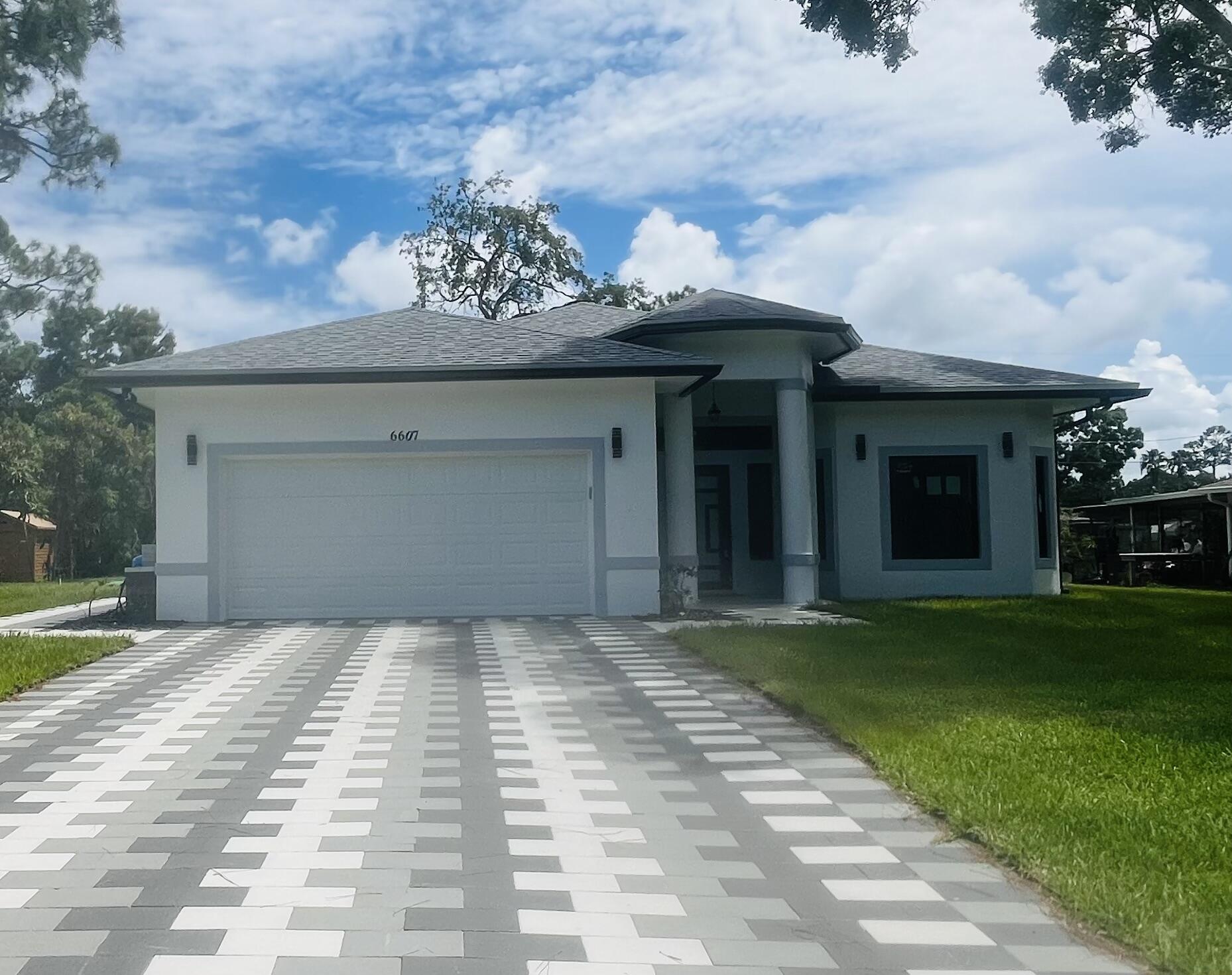 a front view of a house with a garden and trees