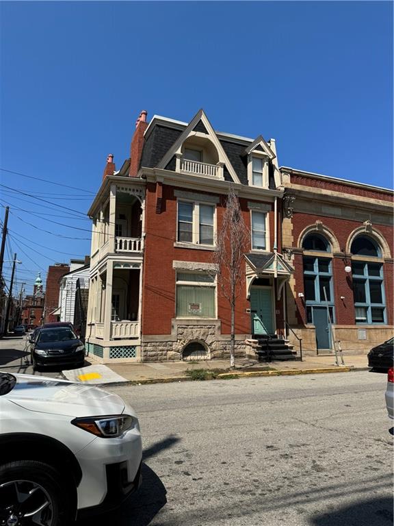 a front view of a house with cars parked