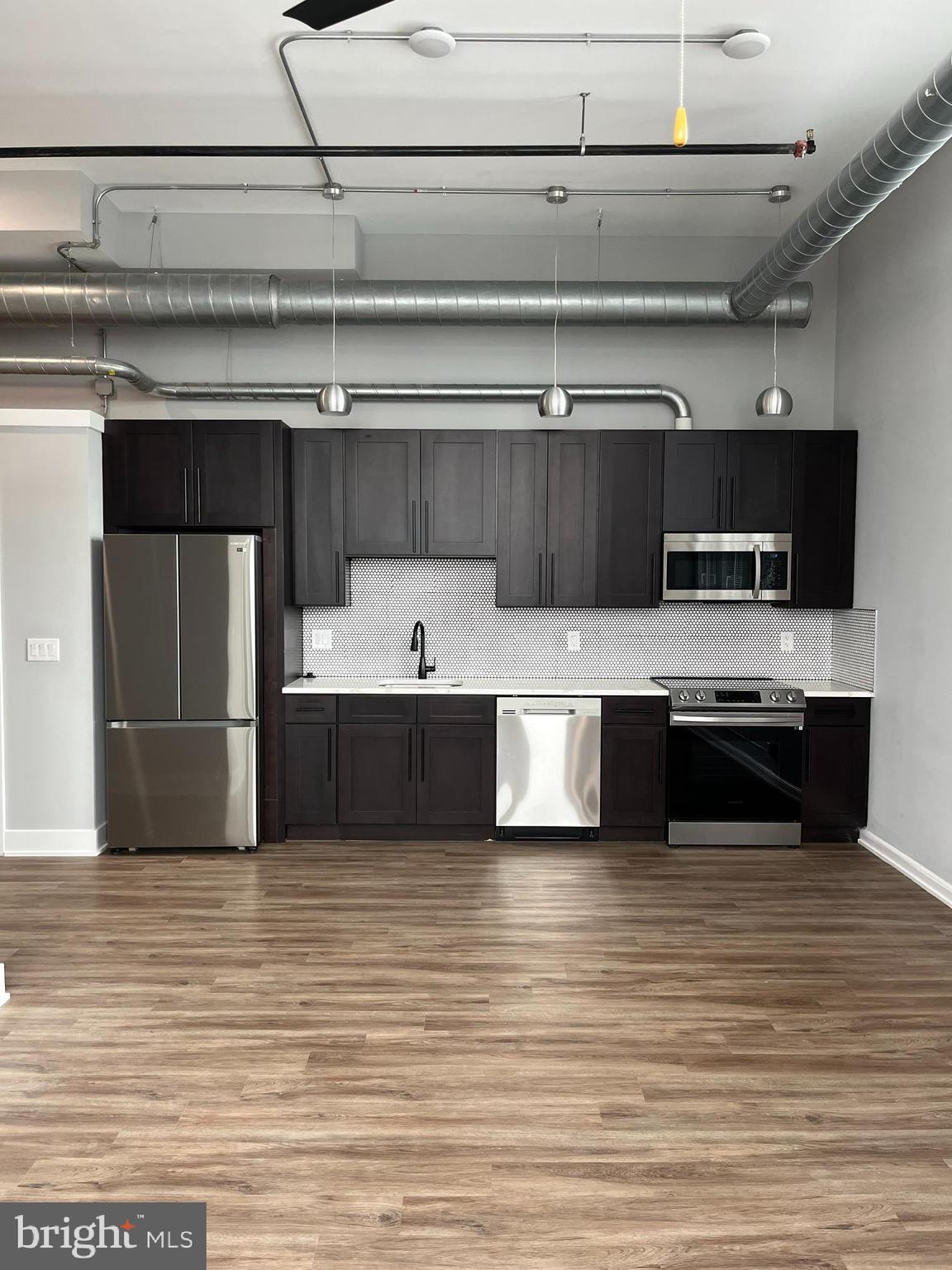 a large kitchen with stainless steel appliances a stove and a refrigerator