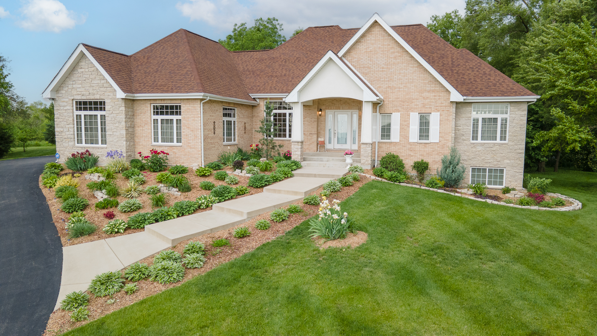 a view of a house with a yard and potted plants