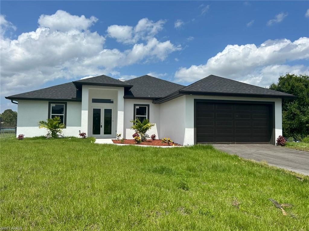 a front view of a house with a garden and yard