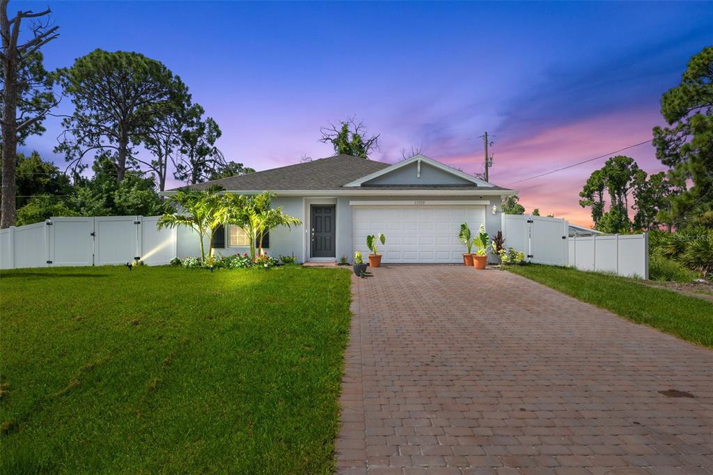 a front view of a house with a garden and yard