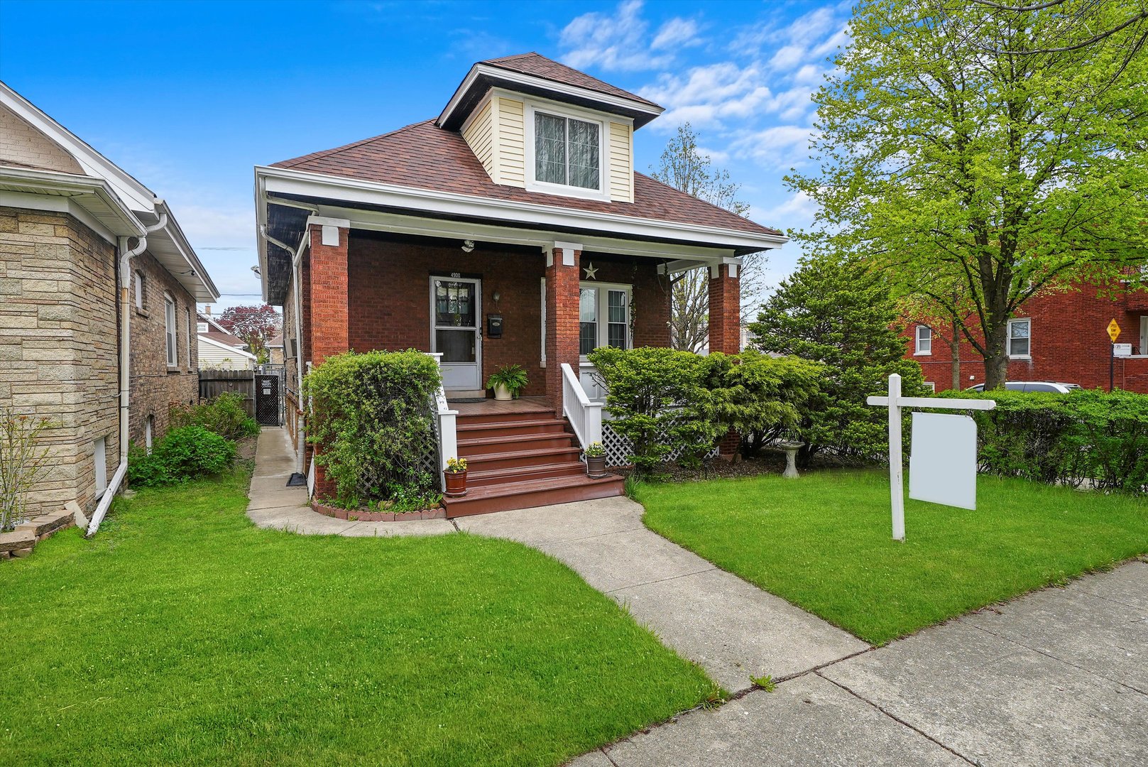 a front view of a house with a yard and trees