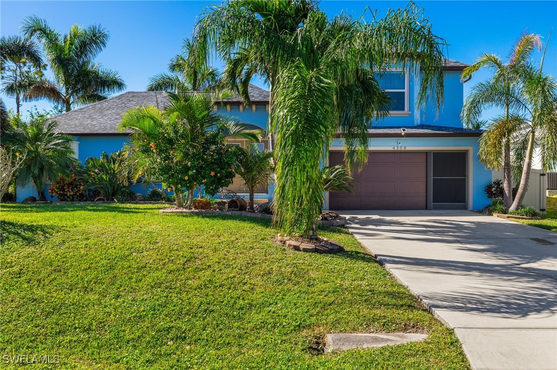 a view of a house with a yard and palm trees