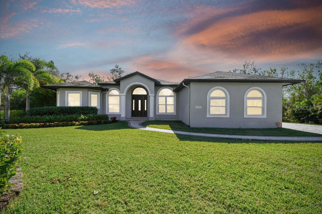 a front view of a house with yard and green space