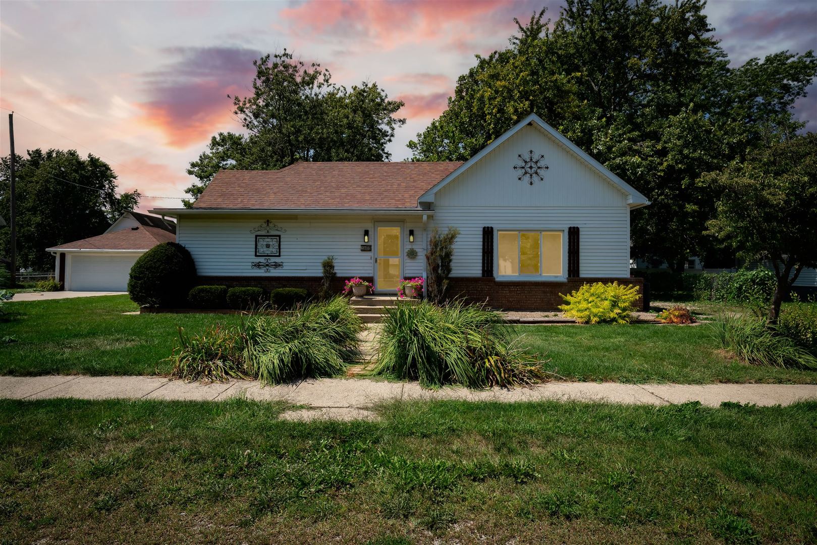 a front view of a house with a garden