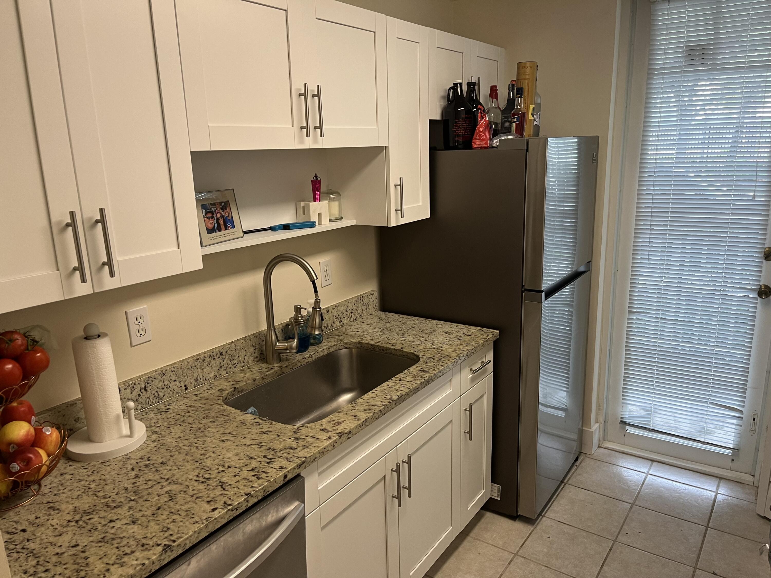 a kitchen with stainless steel appliances granite countertop a sink and a refrigerator