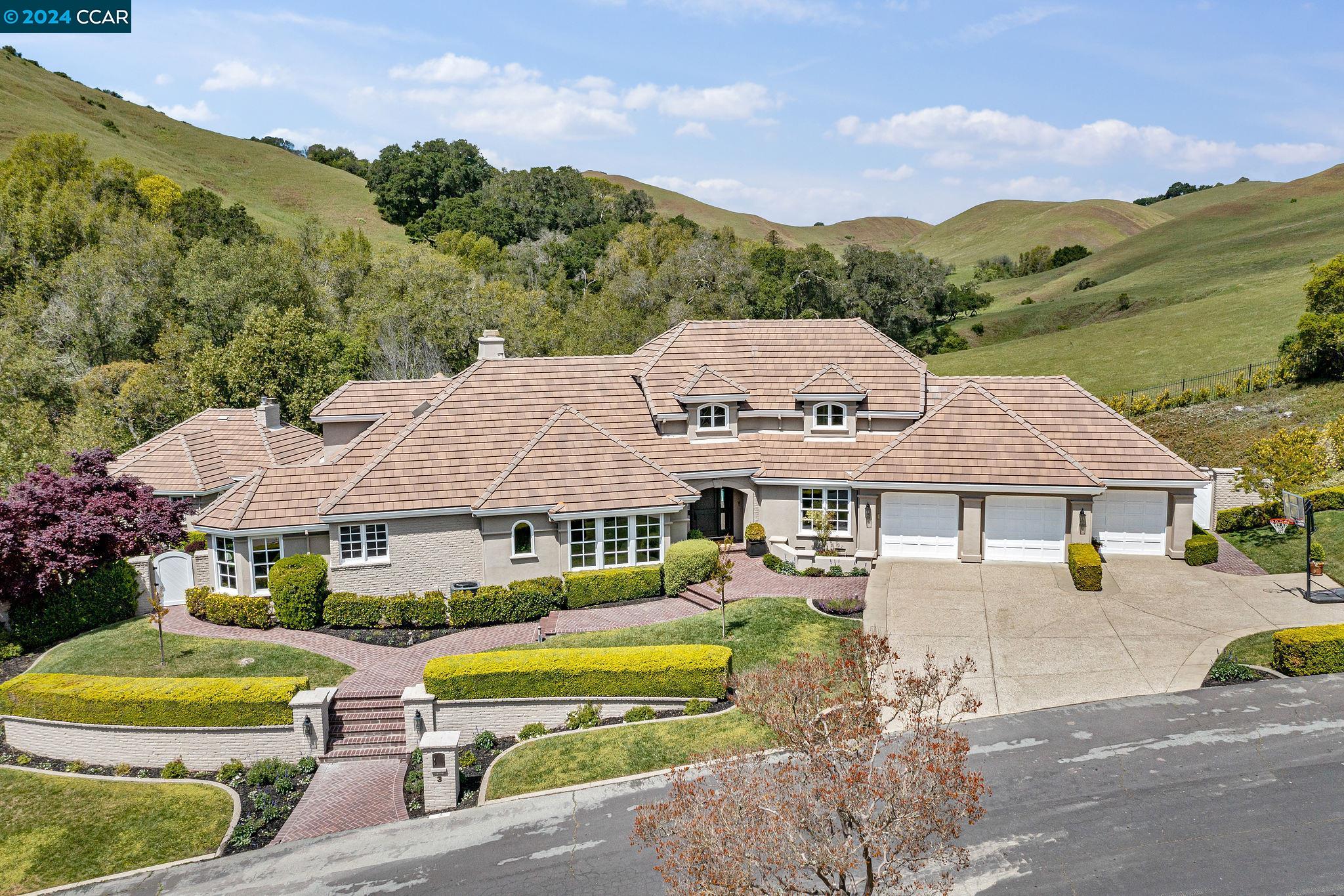 a front view of a house with a garden and lake view