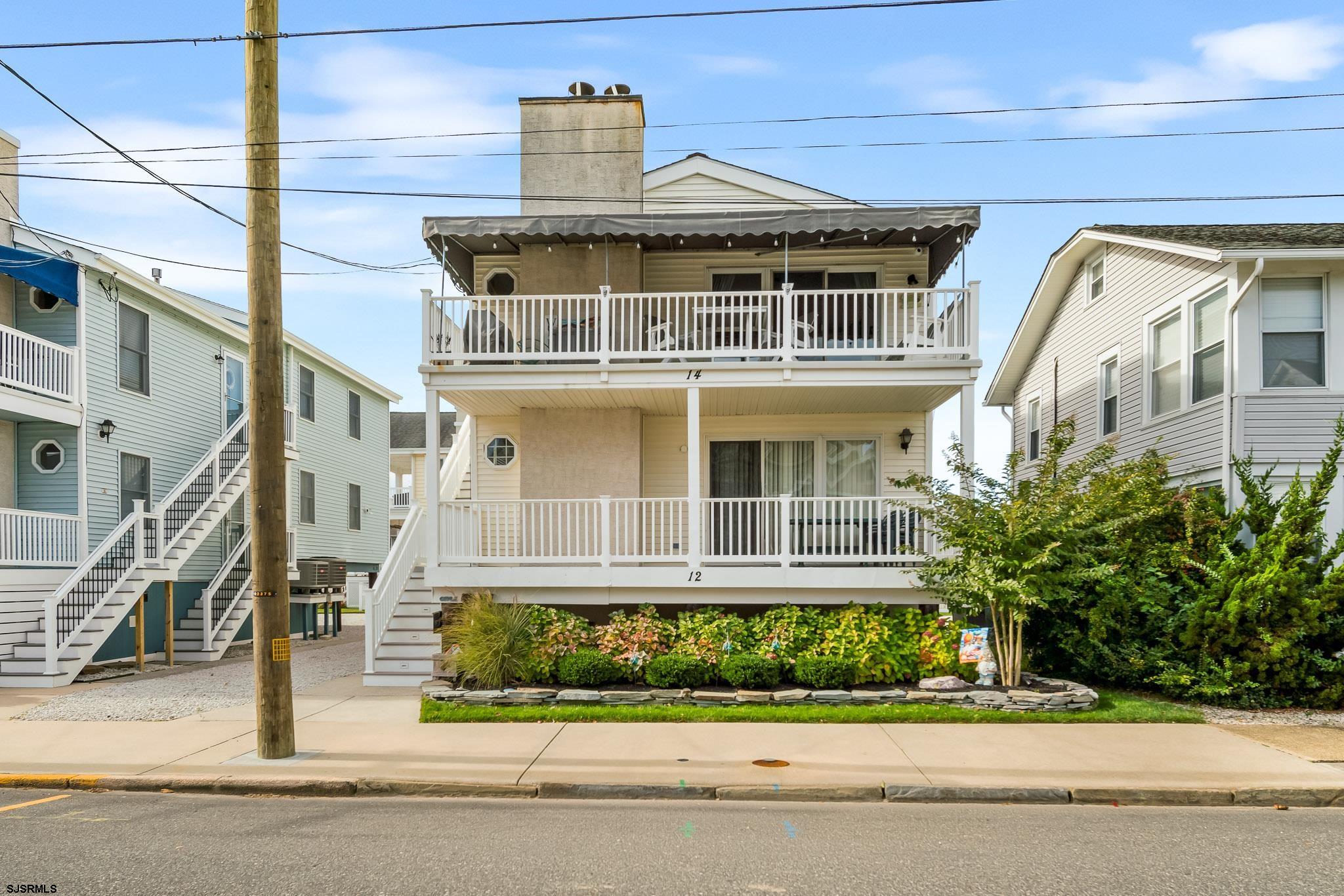 a front view of a house with a garden and plants