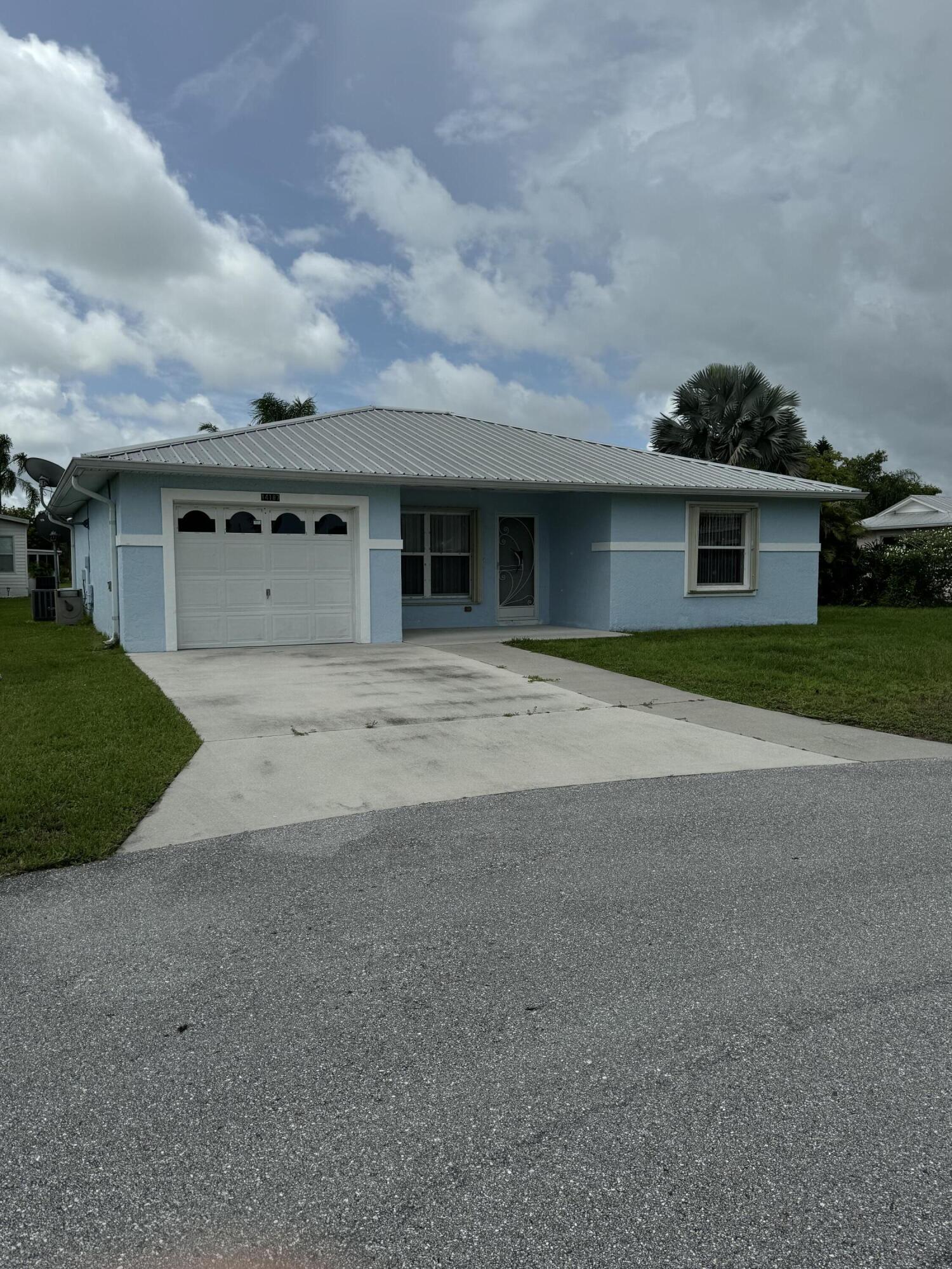 a front view of a house with a garden and garage