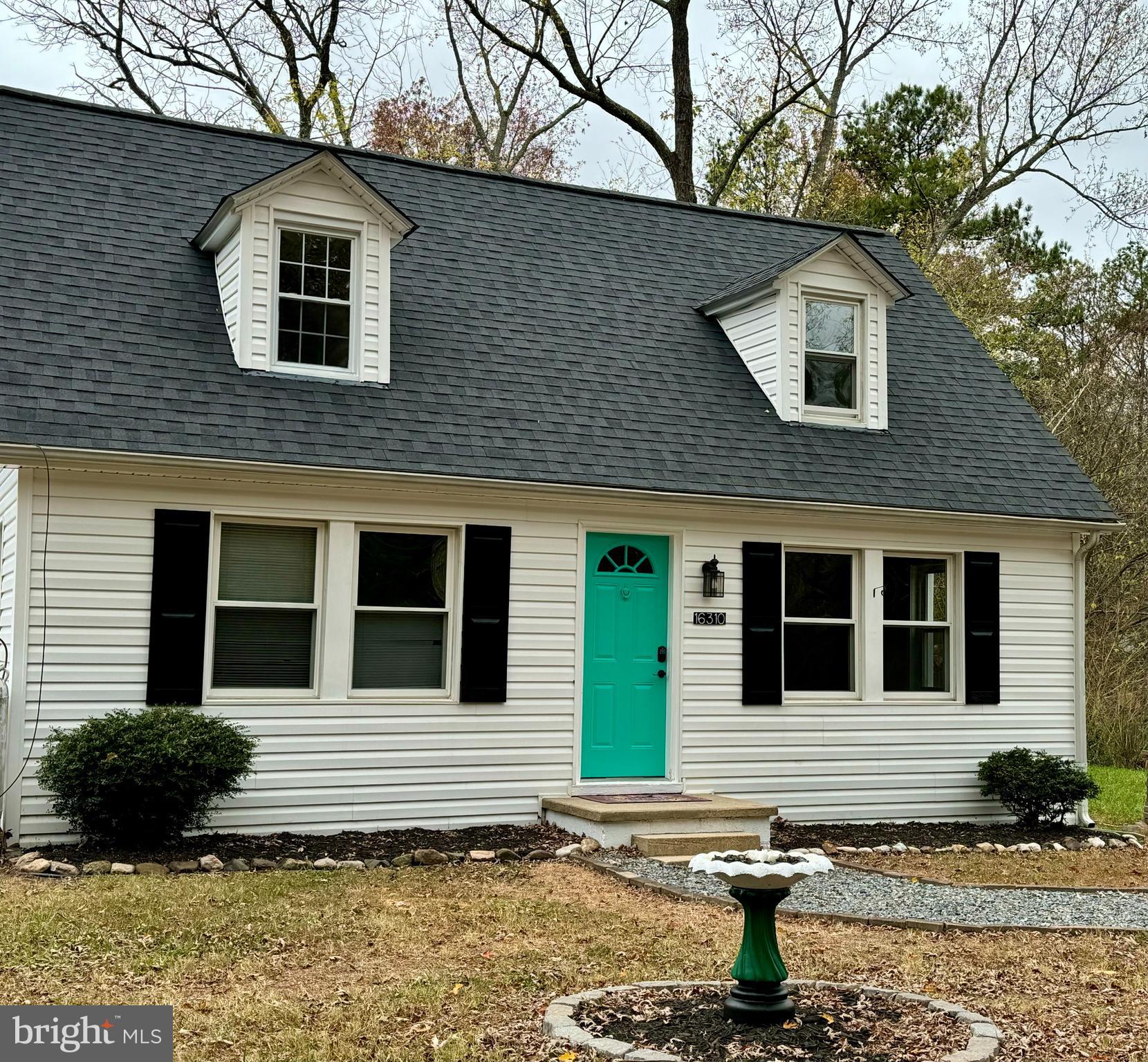 a house that has a large tree in front of it