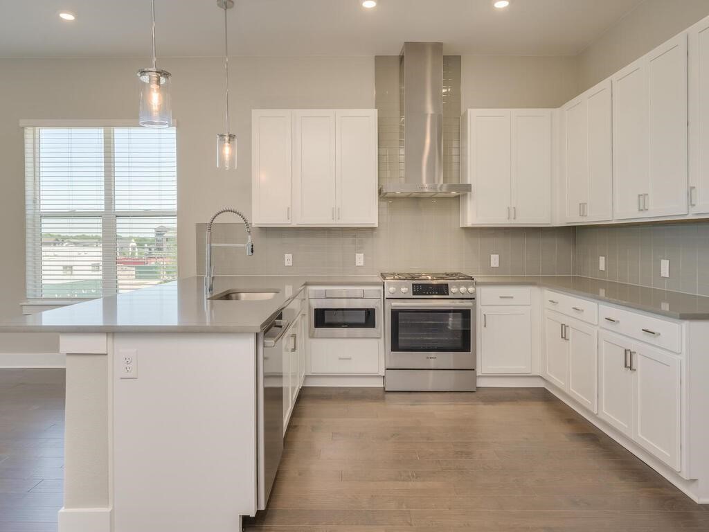 a kitchen with stainless steel appliances granite countertop white cabinets and window
