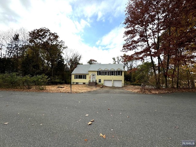 a view of a house with a yard and large trees