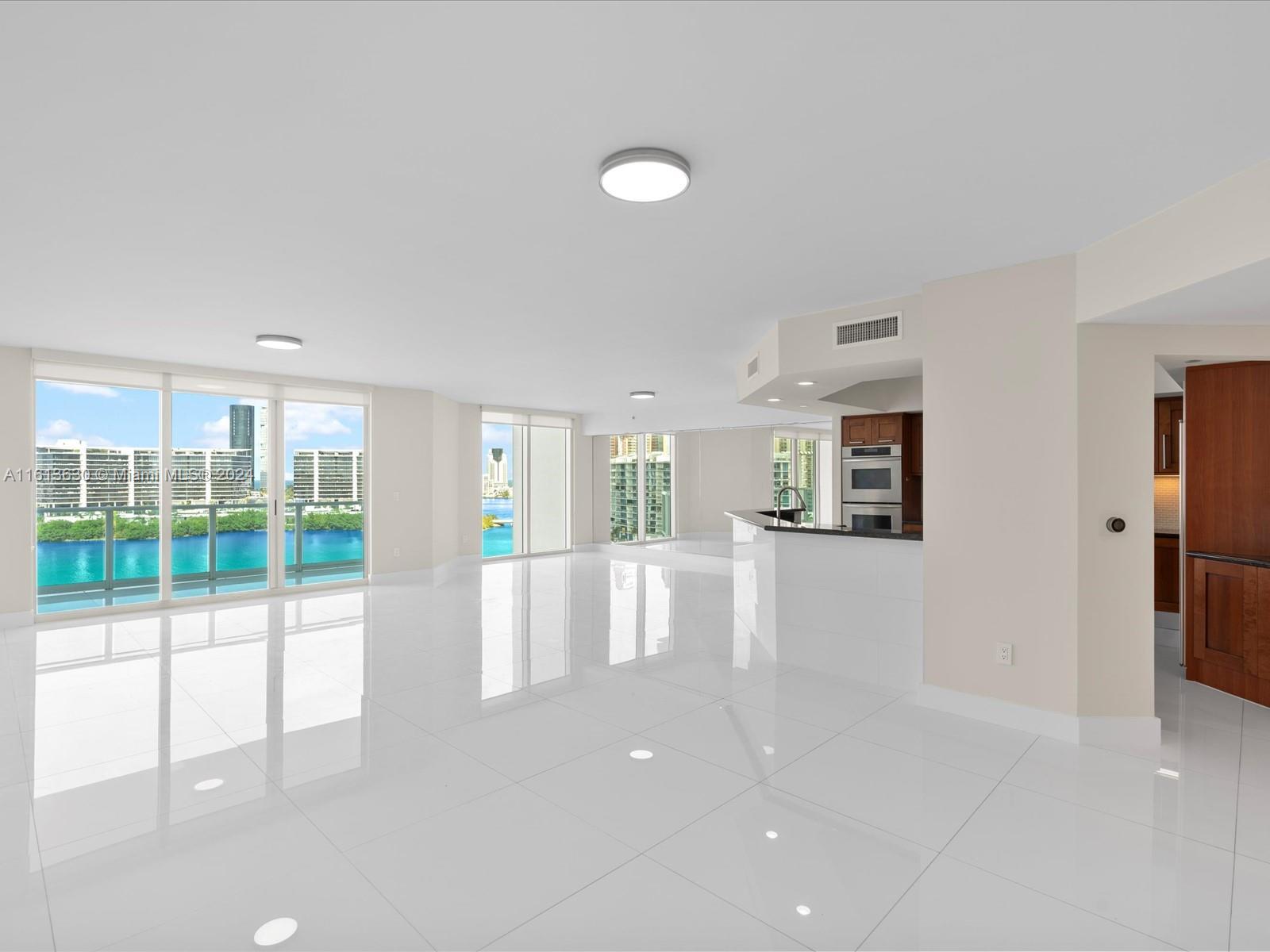 a view of empty room with floor to ceiling window and glass door